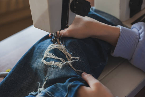Young Dressmaker Woman Sews Clothes On Sewing Machine.