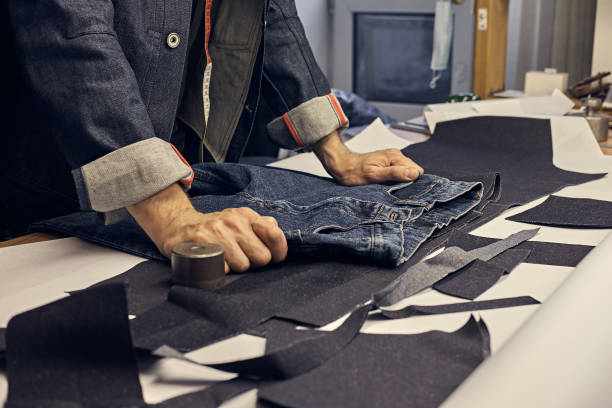 Ropped Image Of A Tailor Working With Jeans Material At A Sewing Workshop.